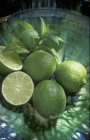 Limes fraîches avec moitiés — Photo de stock