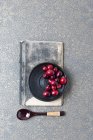 Cranberries on black plate — Stock Photo