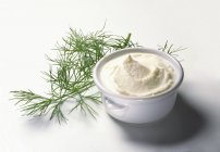 Closeup view of Creme Fraiche and dill on white surface — Stock Photo