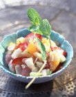 Огірок і фруктовий салат в мисці — стокове фото