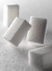 Primo piano vista di grumi di zucchero su una superficie bianca — Foto stock
