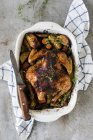 Жареная целая курица с картошкой — стоковое фото