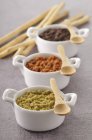 Assorted tapenades in bowls with wooden spoons — Stock Photo