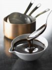 Chocolate sauce in bowl with spoon — Stock Photo