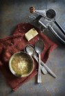 Vista dall'alto di piatto con formaggio grattugiato e cucchiai su stoffa rossa da grattugia — Foto stock