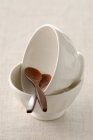 Closeup view of white bowls and wooden spoons — Stock Photo