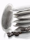 Крупним планом вид круглих кавових пакетів і бобів — стокове фото