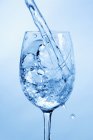 Wasser spritzt in Glas mit Wasser — Stockfoto