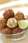 Fried potato balls in glass plate with lime — Stock Photo