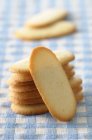 Langues-de-chat stacked on blue tablecloth — Stock Photo