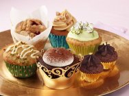 Luxury cupcakes on gold plate — Stock Photo
