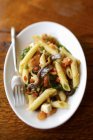 Penne pasta with anchovy and basil fricasse — Stock Photo