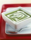 Crema de espárragos verdes con crema en un plato blanco pequeño - foto de stock