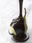 Verser le chocolat fondu sur la poire — Photo de stock