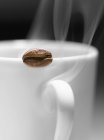 Chicco di caffè sul bordo — Foto stock