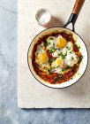 Top view of Shakshuka eggs in a pan and salt — Stock Photo