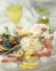 Aoli in small glass pot over glass plate with shrimp and vegetables — Stock Photo