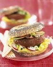 Hamburger in poppy seed bagel — Stock Photo