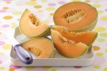 Vista de cerca del melón en rodajas con cuchillo en tazón - foto de stock