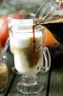 Latte in Glasbecher gießen — Stockfoto