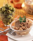 Shredded tuna and green olives in small glass bowl — Stock Photo