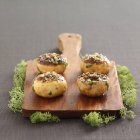 Mushrooms stuffed with hazelnuts and coriander on chopping board — Stock Photo