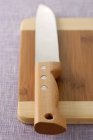 Closeup view of kitchen knife on cutting board — Stock Photo