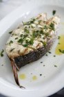 Bistecca di pesce grigliata al barbecue con erbe aromatiche in piatto bianco — Foto stock