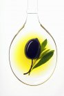 Oliva negra en cucharada de aceite de oliva - foto de stock
