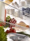 Productos alimenticios frescos en el refrigerador - foto de stock
