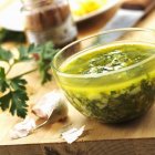 Salsa verde en bwol de vidrio sobre mesa de madera - foto de stock