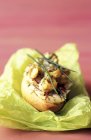 Sea snail crostino with saffron and chives on green paper napkin — Stock Photo