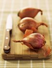 Shallots on wooden board — Stock Photo