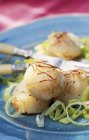 Scallops with saffron on blue plate with fork — Stock Photo