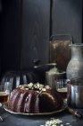 Vista de primer plano de chocolate Baba con bebidas y utensilios de cocina - foto de stock