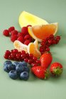 Komposition mit Früchten auf grüner Oberfläche — Stockfoto