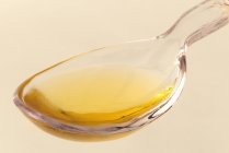 Closeup view of Argan oil in a glass spoon — Stock Photo