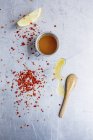 Vista dall'alto di fiocchi di peperoncino e salsa con spicchio di limone — Foto stock