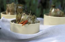 Artichokes in barigoule sauce in white pots over white towel — Stock Photo