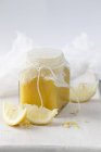 Vue rapprochée du caillé de citron dans un bocal en verre avec des citrons tranchés — Photo de stock