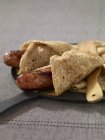 Fried sausage in a buckwheat folded crepe — Stock Photo