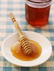 Мед в белой тарелке — стоковое фото