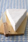 Piece of Brie on wooden board — Stock Photo