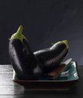 Fresh aubergines on plate — Stock Photo