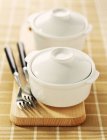 Closeup view of mini casserole dishes with forks on wooden board — Stock Photo
