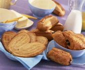 Selection of viennoiseries in blue plates and over blue napkins — Stock Photo