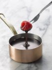 Dipping raspberry into melted chocolate — Stock Photo