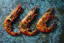 Prawns laying in a row on green marble surface — Stock Photo