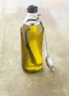 Botella pequeña de aceite con sabor a vainilla con cuchara - foto de stock