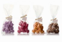 Cuatro bolsas de diferentes merengues con sabor - foto de stock